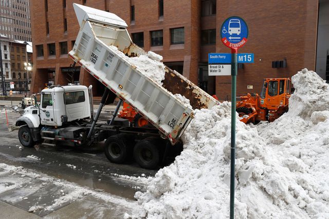 Dump trucks unload snow collected from Manhattan streets.